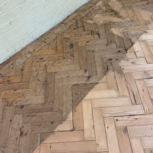 Commercial pine herringbone flooring during sanding